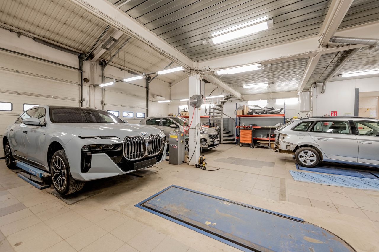 core-values Spacious indoor car garage featuring luxury vehicles under maintenance, showcasing an organized and professional workspace.