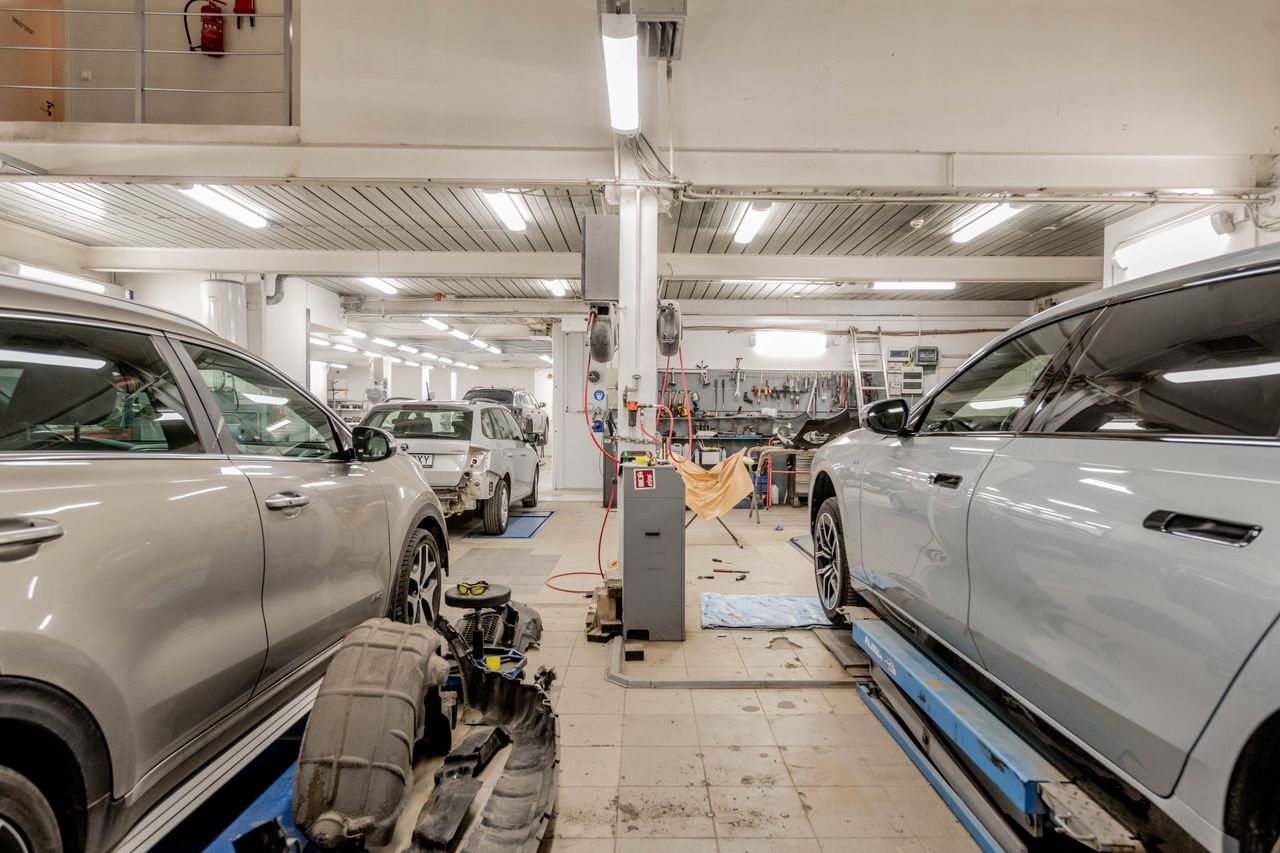our-mission Interior of an automotive repair shop with cars undergoing maintenance and servicing.