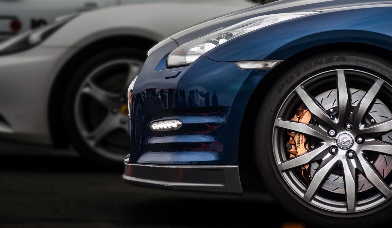 Side view of contemporary expensive automobiles parked next to each other on asphalt road in daytime